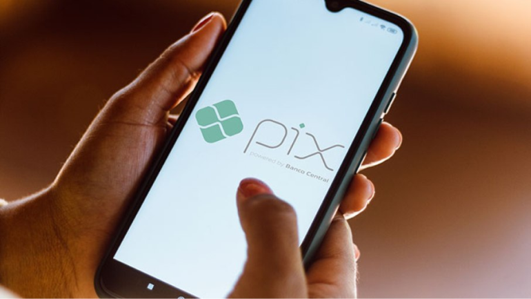 Mão de uma mulher mexendo em um celular mostrando a tela do aplicativo PIX